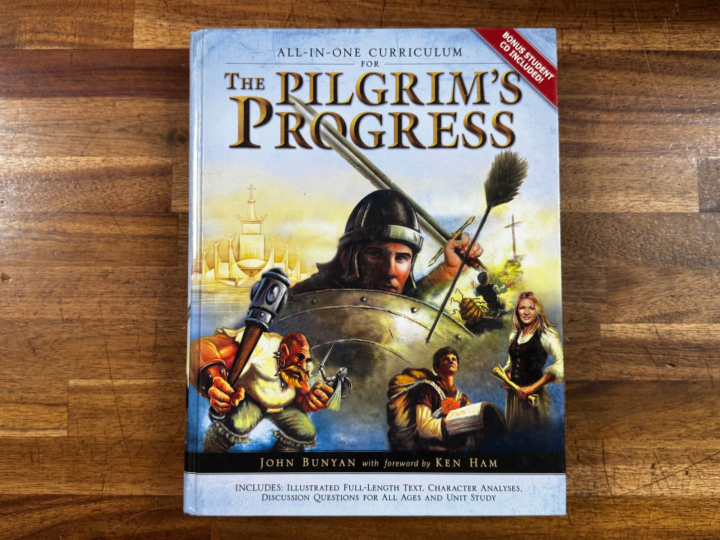Book titled 'The Pilgrim's Progress' on a wooden surface