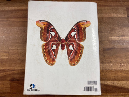 BJU Press Biology Fourth Edition Student Textbook — Acceptable — Item #268078 | Noticeable cover wear with a torn/damaged corner and some edge fraying; no writing inside visible. Highlighting on a few pages.